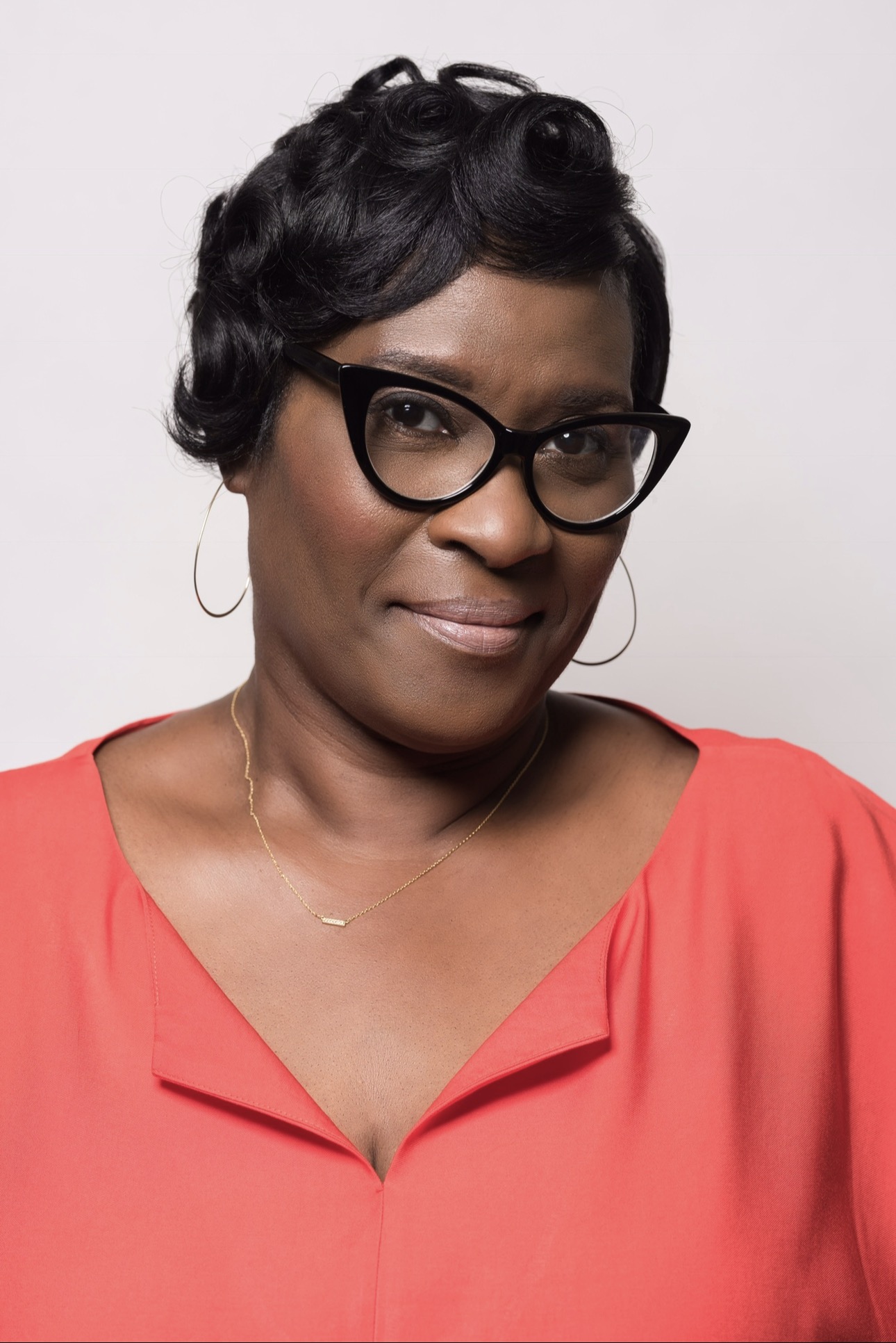 Tracy Lee Carter wearing glasses and a coral blouse